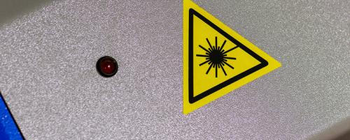 Yellow triangular laser warning label on Flexilase™ engraving material