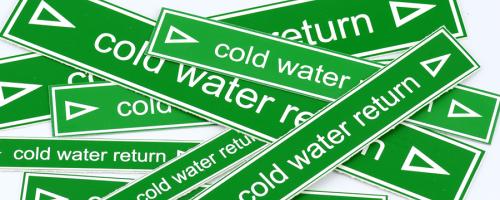 Multiple cold water return labels made of green Gravofoil™ engraving material